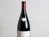 la bouteille de vin rouge est posée sur une table en bois