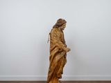 an image of a statue of jesus standing on a wooden floor