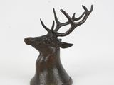 une image représentant une statue en bronze d'un cerf avec des bois sur la tête