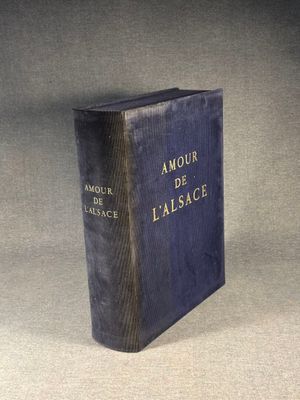 an old book sitting on top of a table on a gray surface