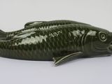 green ceramic fish figurine sitting on a white surface