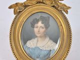 an old picture of a woman in a blue dress with a bow around her neck
