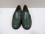 a pair of green loafers on a white surface