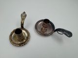 deux bougeoirs en argent posés sur une table blanche