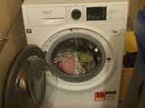 a washing machine in the corner of a small room