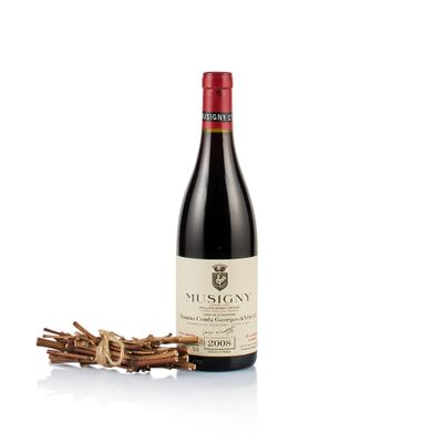 a bottle of wine sitting next to a bunch of sticks