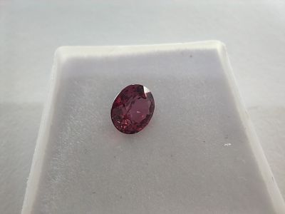 un gros plan d'un diamant rose sur une surface blanche