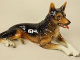 a figurine of a dog laying down on the ground