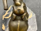 statue of an elephant sitting on top of a gold ball