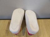 pair of white and pink tennis shoes sitting on top of a wooden table