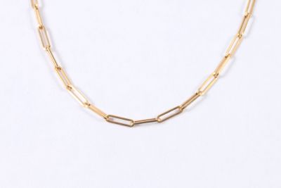 gros plan d'un collier en chaîne en or sur fond blanc