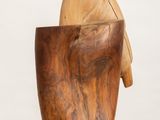 a wooden bowl with a wooden handle on a white surface