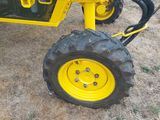 a yellow tractor with a big tire on the ground
