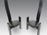 une paire de fauteuils en cuir noir à dossier incurvé