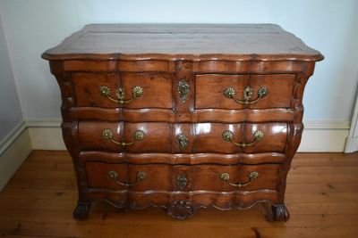 a wooden chest of drawers on a hard wood floor