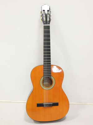 une guitare orange posée sur une surface blanche