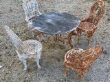 quatre chaises et une table posées sur le sol recouvert de gravier