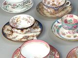 many cups and saucers sitting on a table