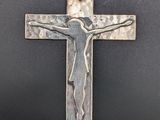 a silver cross with a jesus on it on a black background