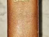 un vieux livre à la couverture en cuir posé sur une surface en marbre