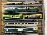 plein de petits trains miniatures dans une boîte posée sur la table