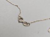 a close up of a gold chain with a heart on it
