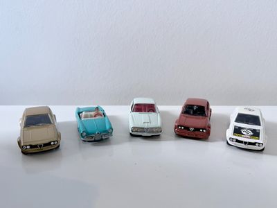 plusieurs petites voitures sont alignées sur une surface blanche