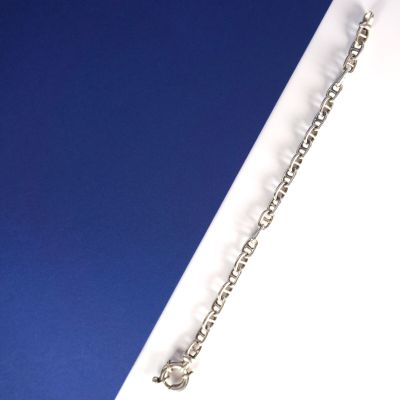 Bracelet à chaîne plaquée argent avec une breloque en forme de cœur sur fond bleu