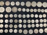 a large collection of silver coins on a black background