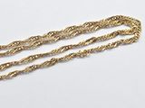 a close up of three gold chains on a white surface