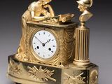 une horloge en or surmontée d'une statue
