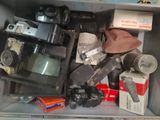 a metal box filled with old cameras and other items