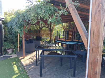 a patio with a table and chairs under a pergol roof