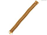 gros plan d'un bracelet en or sur fond blanc