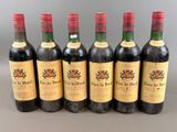 six bottles of wine are lined up in a row on a table