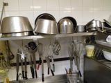de nombreuses casseroles et poêles sur l'étagère de la cuisine