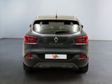 the rear end of a grey car in a white room
