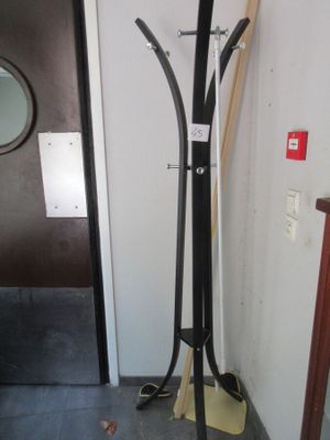 un porte-manteau sur lequel sont posés une paire de skis et deux balais