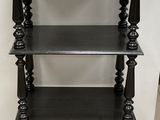 an image of a black shelf with three shelves on top of it