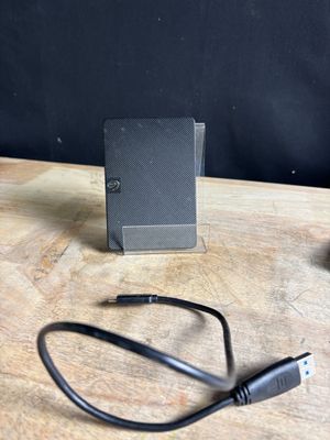 a small black device on a table with a charger attached to it