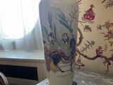 a vase sitting on a table with a lamp on top of it