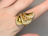 someone is holding a gold ring with diamonds on it on a finger