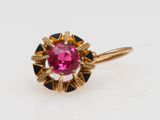 a close up of a pink and black ring on a white surface