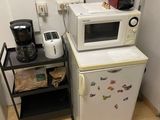 two microwaves and a coffee maker in a small kitchen