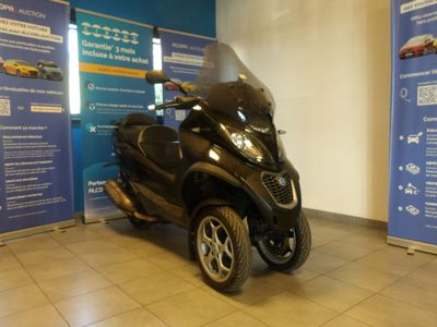 un scooter garé devant un mur bleu