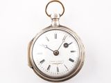 une montre de poche en argent avec des chiffres romains sur le cadran