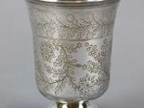 an antique silver cup with a floral design on the rim