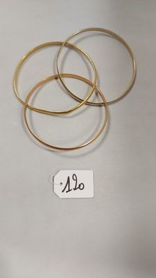 trois bracelets rigides en or sur fond blanc, avec une étiquette de prix