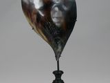 a large horn shaped object on a black stand next to a bird