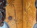 a close up of a wooden table with a painting on it